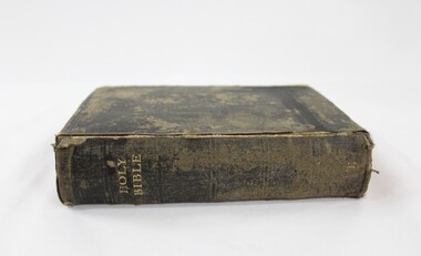 A black cloth bible with Holy Bible embossed on the spine in gold  
