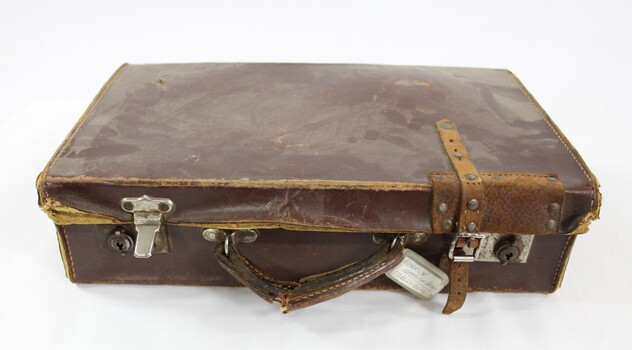 A closed brown vinyl suitcase 