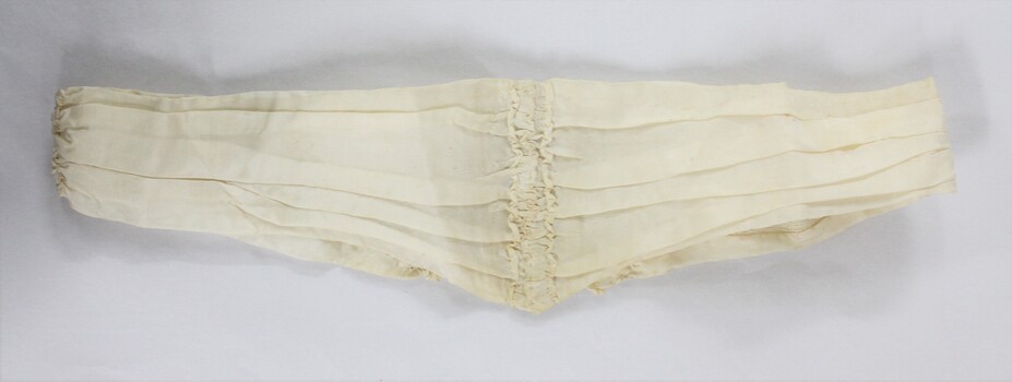 A cream coloured dip-waist belt with metal clasp 