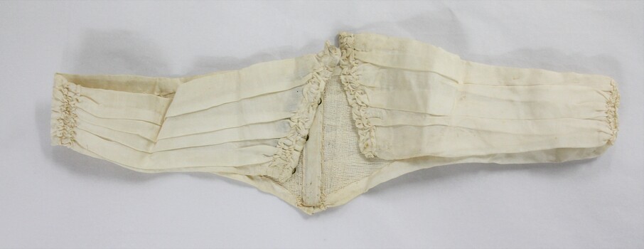A cream coloured dip-waist belt with reserve showing metal clasp 
