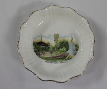 A white glazed china souvenir bowl. Frilled edge.  Includes a painted representation of Woodland Grove, Wodonga, Victoria
