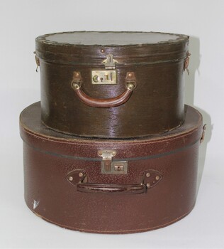 Two brown hat boxes, one small and one large 