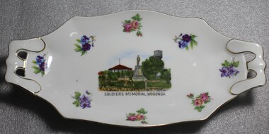 An oblong china dish. White with floral emblems and image of Soldiers Memorial, Wodonga