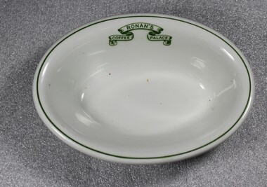 An oval shaped bowl with dark green trim and logo