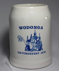 A white china beer stein bearing the blue logo of the Wodonga 1979 Oktoberfest