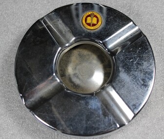 Circular metal ashtray including the Wodonga High School logo