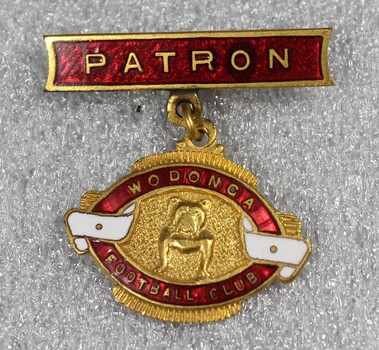 Oval shaped badge and clip of the Wodonga Football Club in gold, maroon and white colours.