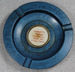 A blue metal ash tray bearing the name SARROFF's Dry Cleaners in the centre