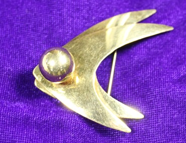 Front of gold-toned metal brooch from the Sarah Coventry Pty. Ltd. with one clear faux gem