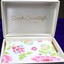 Inside of jewellery box, white with floral paper lining. Sarah Coventry company logo on inside of lid