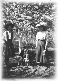 Mrs. Walter McFarlane on the right with two children, standing under tree in full bloom