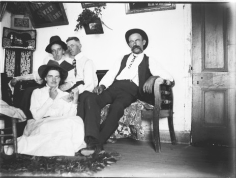 A photo of Mr. and Mrs. Young and their children seated inside their house.