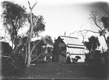 On the right of the image Mrs. Egan is standing and holding a baby. 