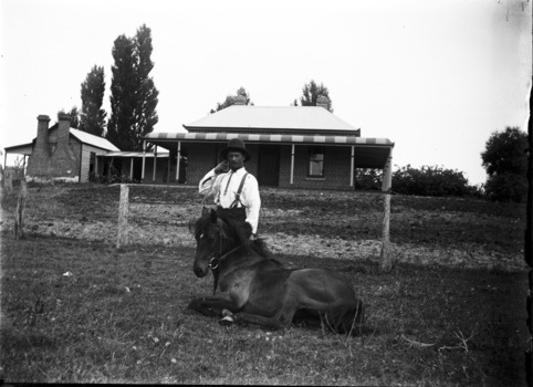 Jack Parker and his pony in the centre front of the image. A house and some outbuildings in the background.