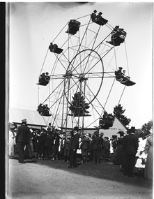 A large group of people gathered in front of a Ferris wheel. Building labelled "Banquet Hall" is in the background.