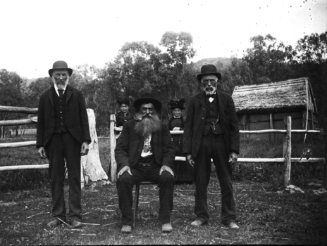 Group of three men and two women from the Haeusler and Klinge families. There is a small structure on the right hand side.