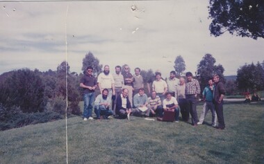 Group of railway employees in gardens with trees in the background.