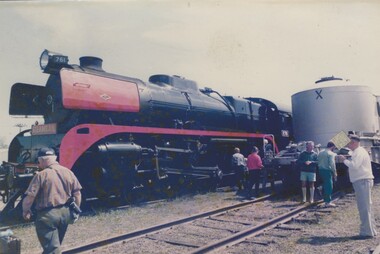 A red and black locomotive and a group of railway workers in Albury.