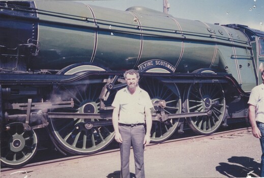 Jimmy Taylor standing beside the Flying Scotsman locomotive