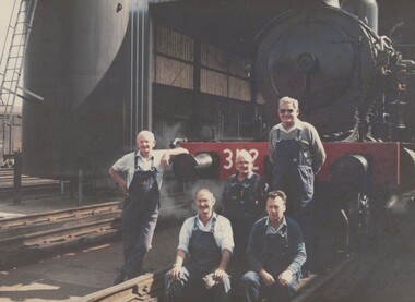 5 railway men standing in front of a locomotive