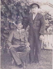Driver George Henry Lynch standing with Fireman Jack Anderson seated.