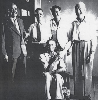 5 men at the retirement function of Jack Schmidt who is seated.