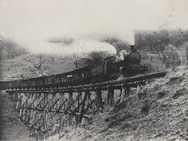 Steam Locomotive passing over trestle bridge