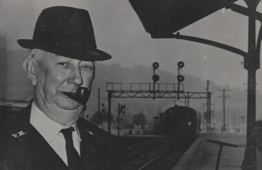  Guard H Fraser's to the left of the image with a locomotive in the background.