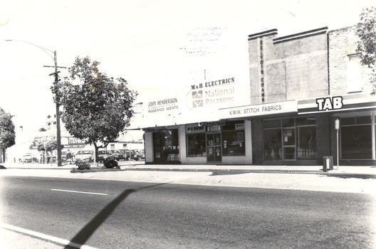 Row of businesses -  Holloways Motors,  John Henderson & Associates, M & H Electrics, Kwik Stitch, T.A.B