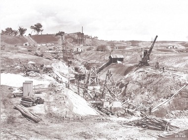 Excavation for core wall in foreground and earth embankment in background