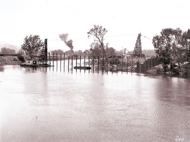 A row of piles for coffer dam across the river to hold back water and enable construction.