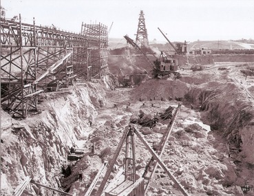 Excavations, machinery and workmen inside coffer dam.
