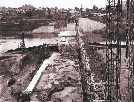 View of concrete dam from top of tall tower pillar. 