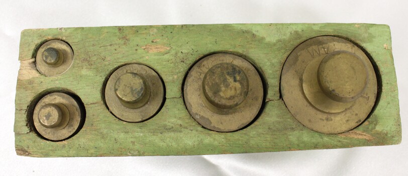 Top view of 5 different sized weights in wooden holder