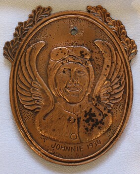 Reverse of Medallion featuring representation of Amy Johnson.