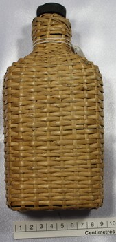 Bottle in rattan cover with scale