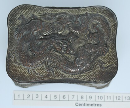 Metal jewellery box top view with scale.