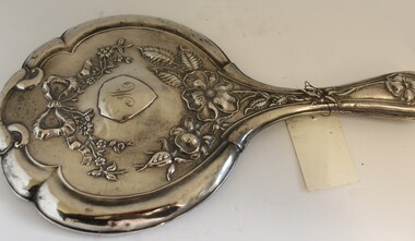 Silver hand mirror showing embossed design