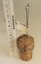 Hat pins stuck into cork with scale in centimetres.