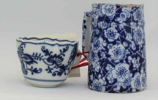 A navy blue and white milk jug and cup with floral design