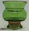 Small green glass vase with 3 flared feet and gilt trim.