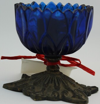 Blue glass pen wiper on metal base.