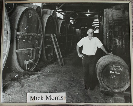 Mick Morris standing with barrels in the Morris' cellar.