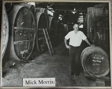 Mick Morris standing with barrels in the Morris' cellar.