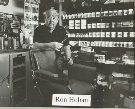 Barber standing behind chair, scissors in hand