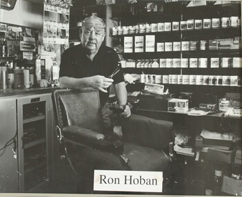 Barber standing behind chair, scissors in hand