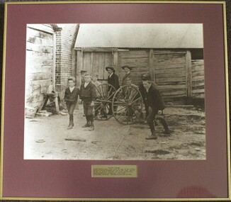 A group of boys playing with a fire cart c 1900