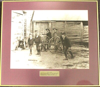 A group of boys playing with a fire cart c1900