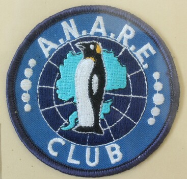 Cloth badge of the ANARE club 1982 featuring the Antarctic region behind a central penguin