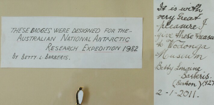 Written notes included in frame with badges including dedication by Betty Barberis